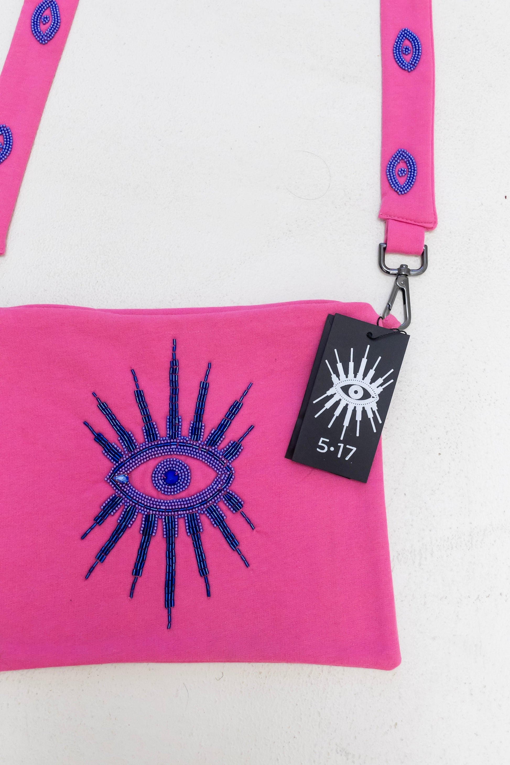 Sustainably and ethically handcrafted pink purse dress with a beaded eye pattern.