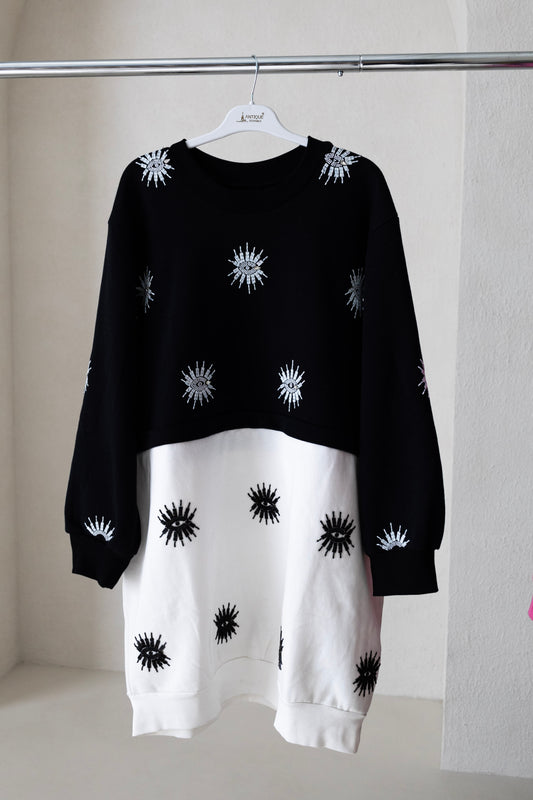 Sustainably and ethically handcrafted black and white convertible sweatshirt dress with a beaded eye pattern.