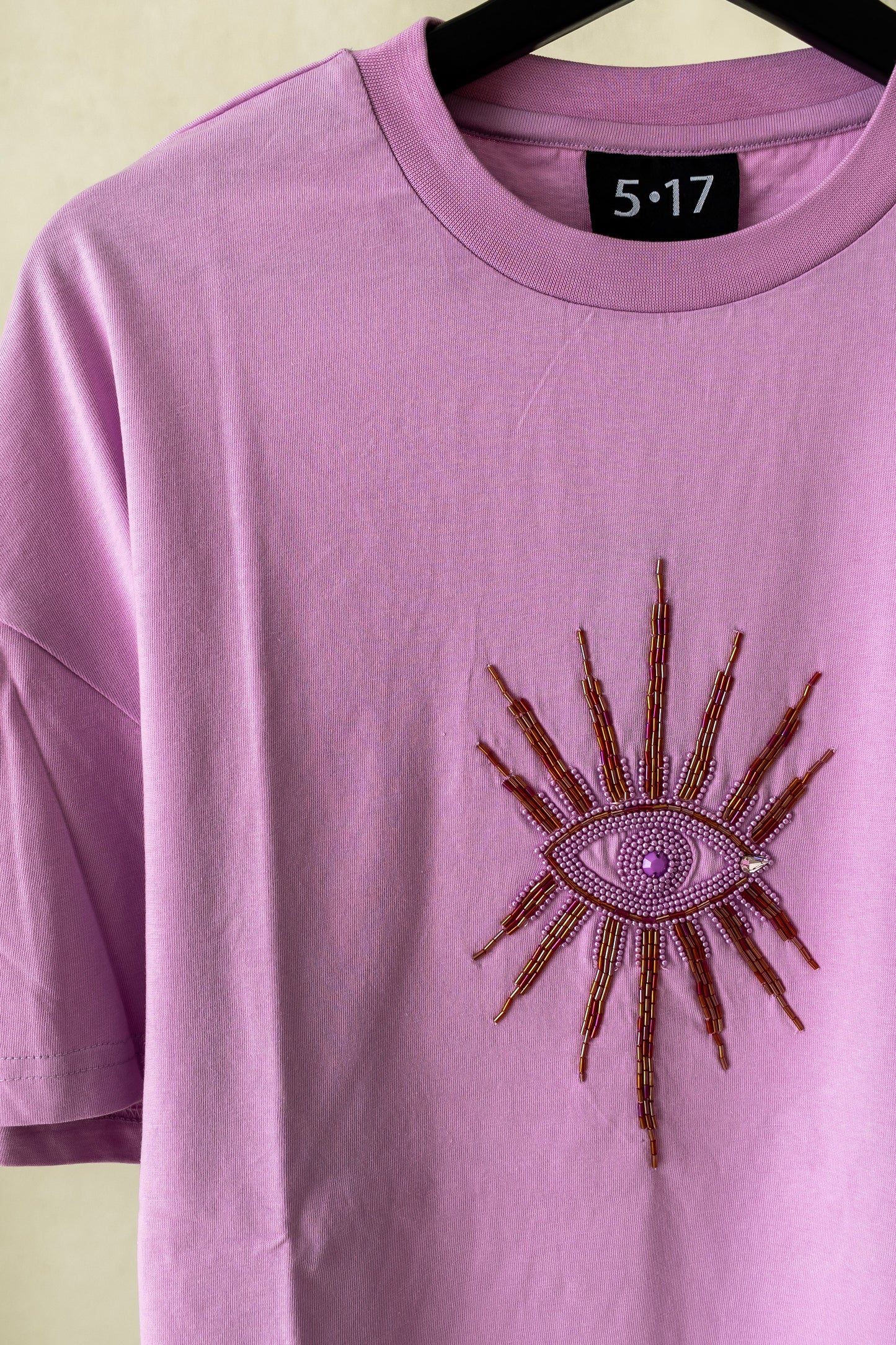 Sustainably and ethically handcrafted lilac shirt with a beaded eye.